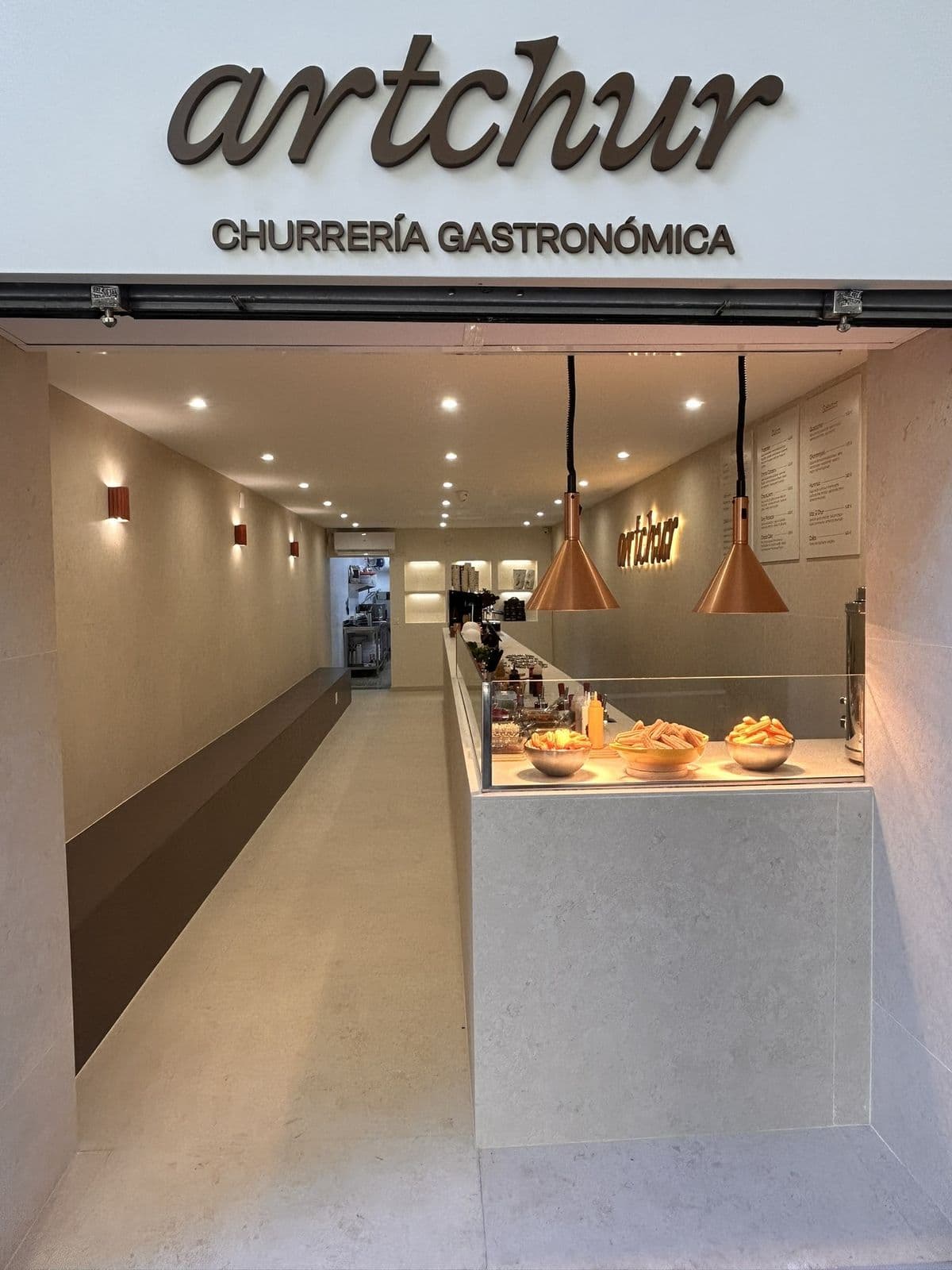 Fachada de la churrería Artchur con rótulo exterior y vista del interior