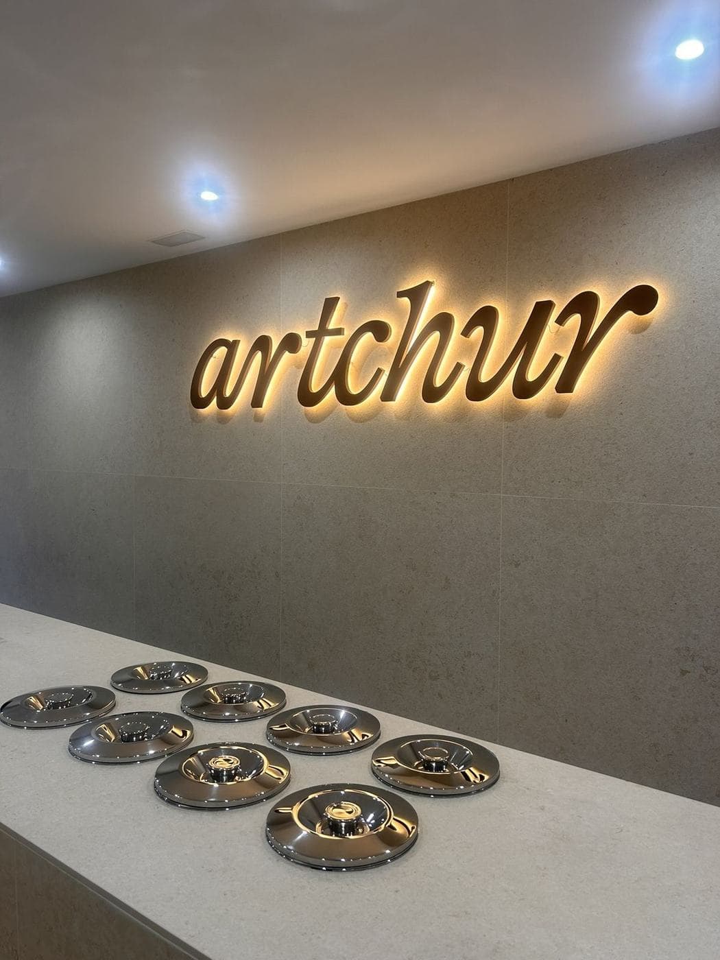 Detalle del rótulo retroiluminado y la barra con platos metálicos