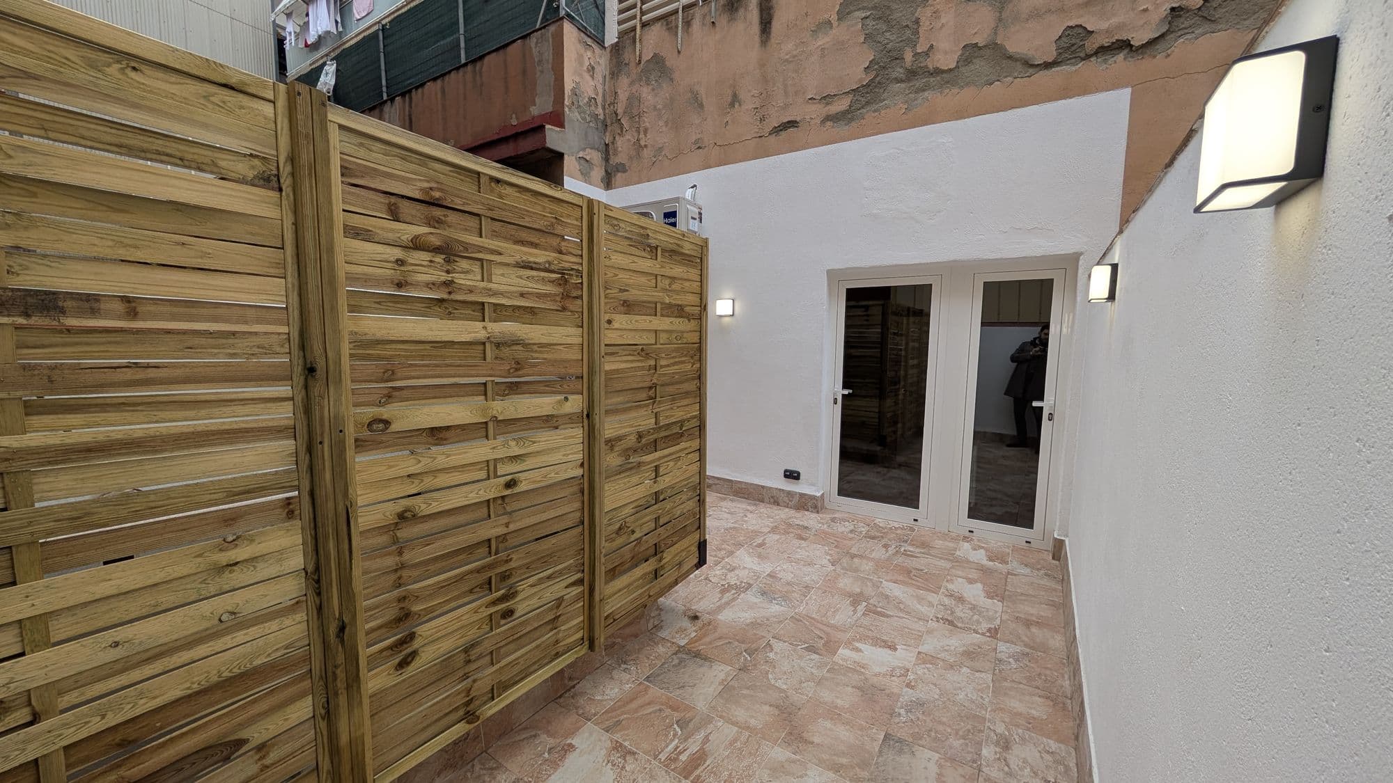 Patio con paneles de madera, pavimento cerámico y aplique de pared