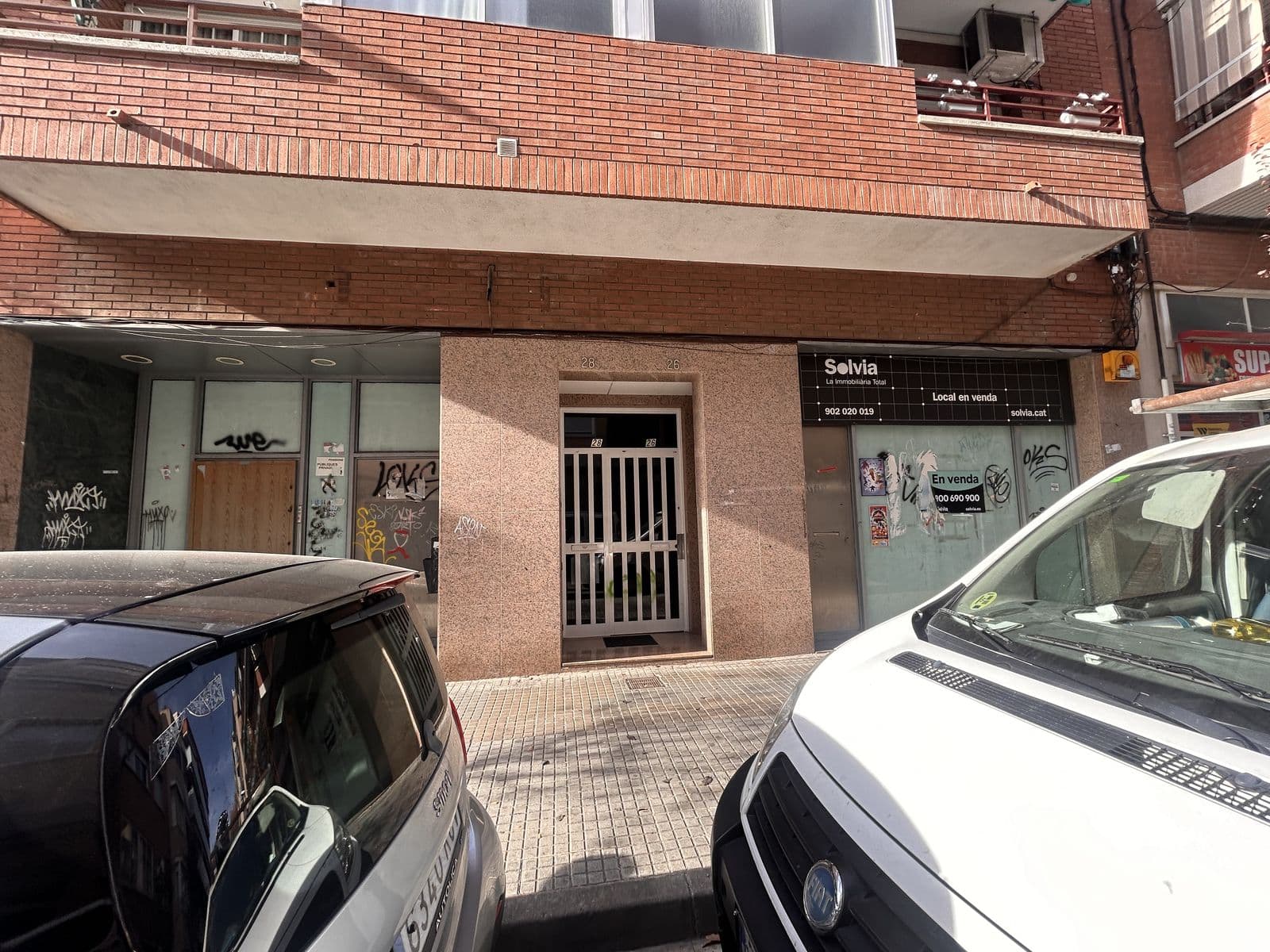 Fachada de la antigua sucursal: aplacado de piedra, puerta enrejada y escaparate