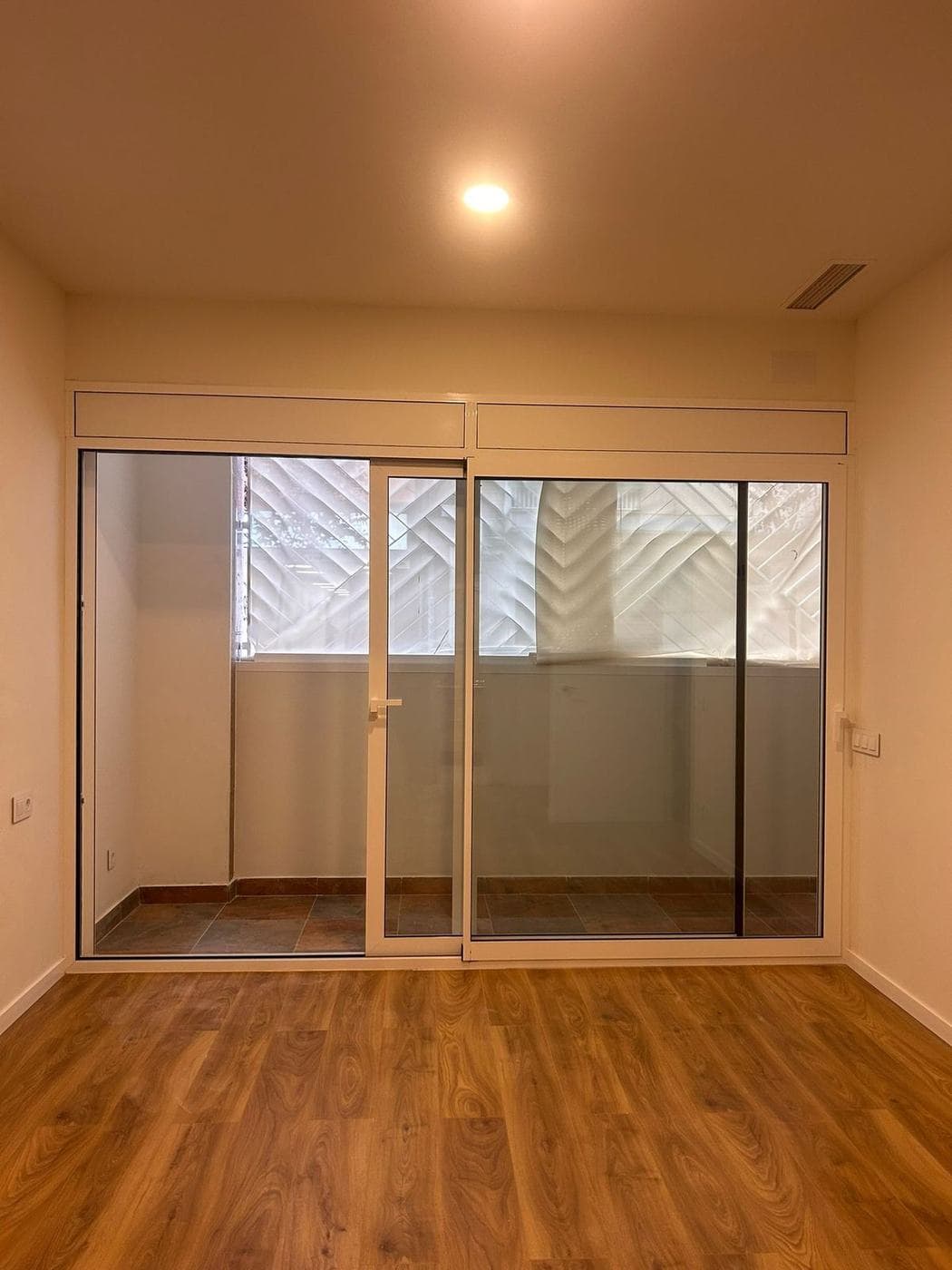 Salón con ventanal corredero abierto a la terraza