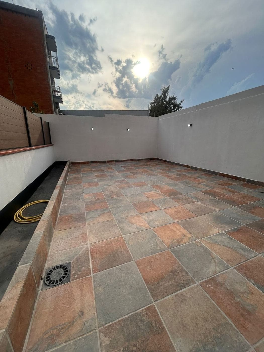 Terraza reformada con pavimento de gres y frente de lamas